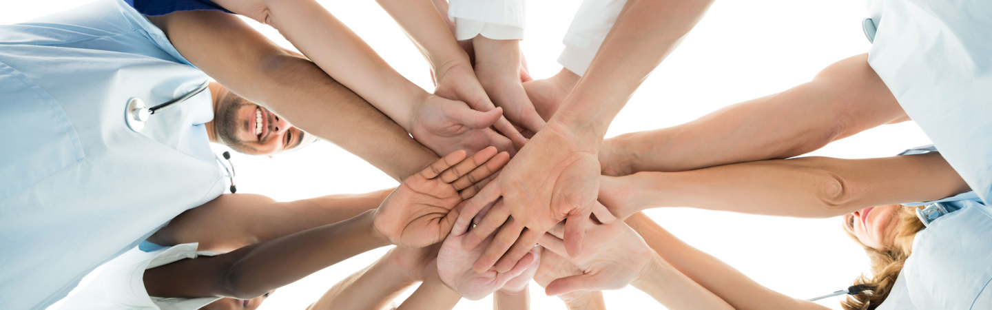 Sjukvårdspersonal bildar ring med händer
