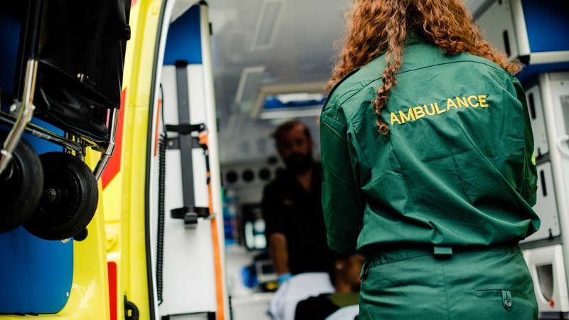 Ambulanspersonal med bår i ambulans