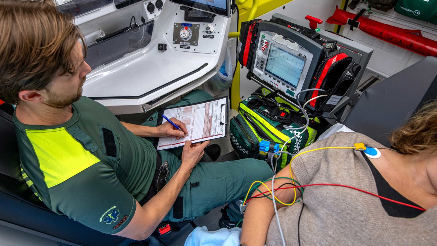 Ambulanspersonal med patient i ambulans