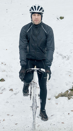 Jonathan Hallvede på cykel iklädd sin cykeljacka