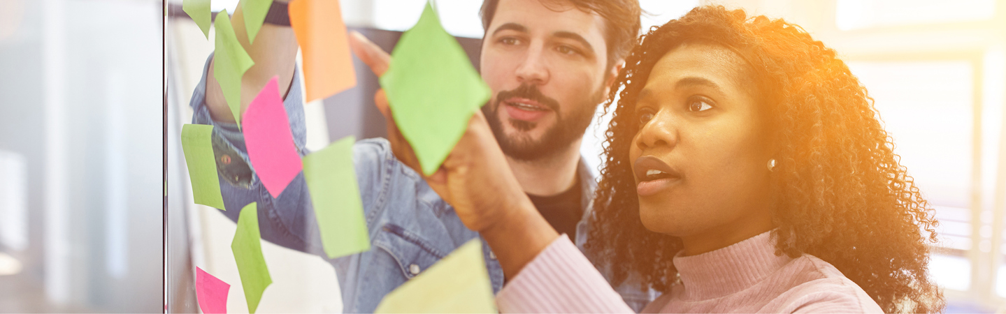 Studenter som jobbar med post-it lappar på glasruta