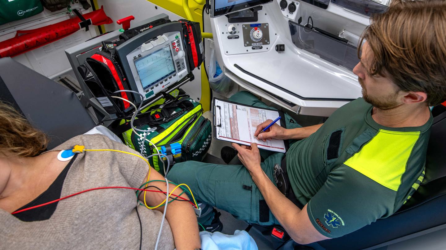 Ambulanspersonal och patient inne i en ambulans.