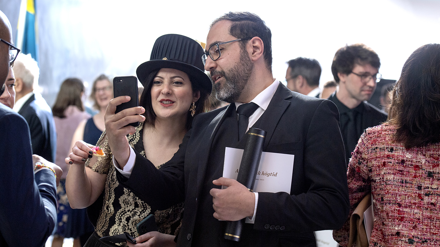 Nypromoverade doktorn May Kahoush tar en selfie med sitt sällskap bland minglande gäster.