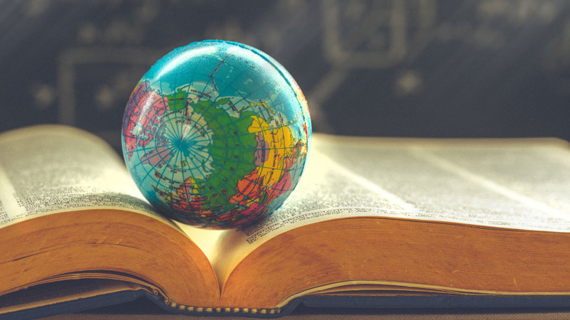 Small globe resting in an open book