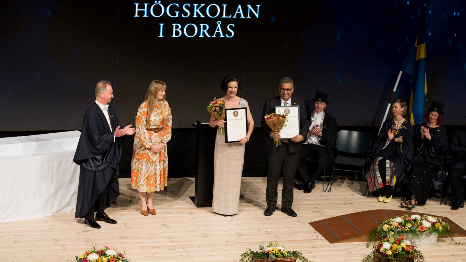 Jeanette Carlsson Hauff and Kamran Rousta holding their diplomas