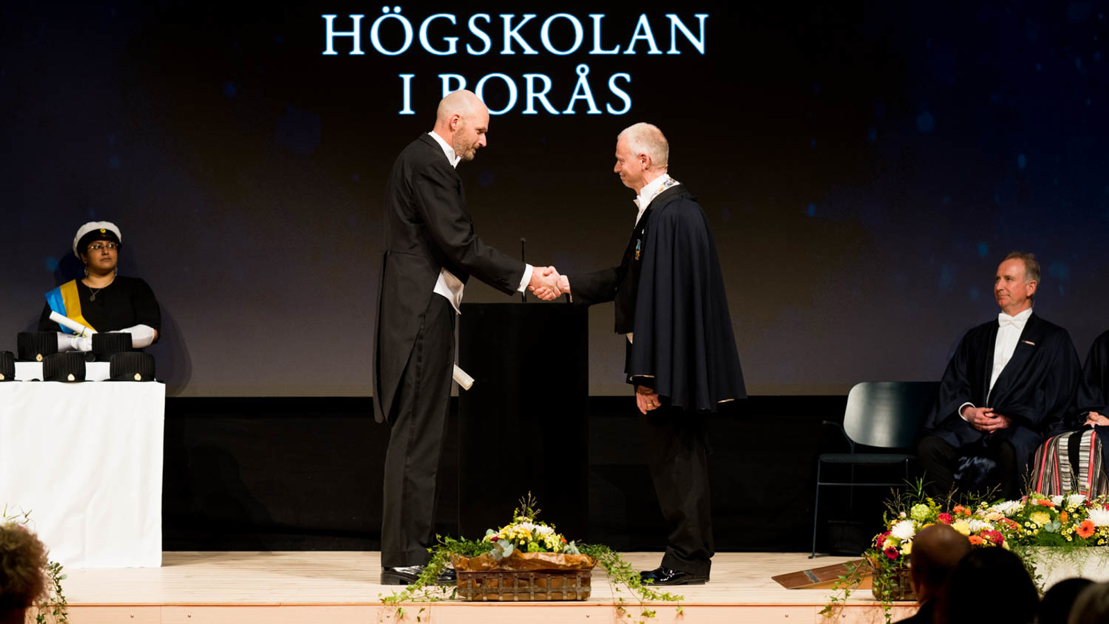 Professor Magnus Andersson Hagiwara is shaking hands with Vice Chancellor Mats Tinnsten