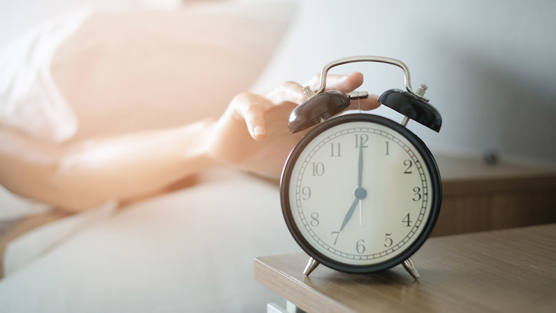 En hand stänger av väckarklockan