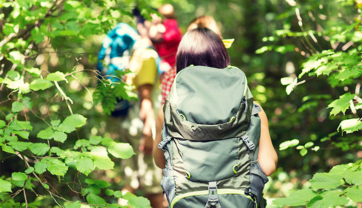 Bild på studenter som går i skogen med ryggsäck