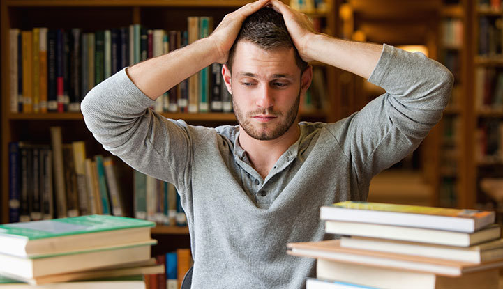 Stressad student med många böcker